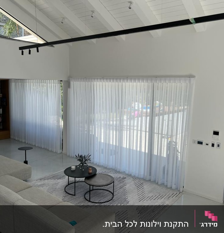 וילונות לבנים שקופים תלויים על חלונות גדולים